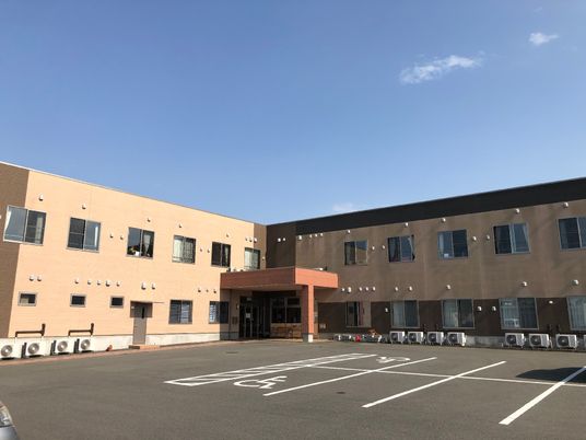 広々とした駐車場の施設外観
