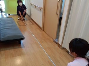 職員が距離を測る居室  