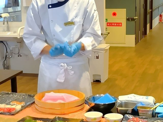 調理スタッフと食材の廊下 廊下 料理を準備するスタッフの様子が見られます。技術を活かした職場環境が魅力です。