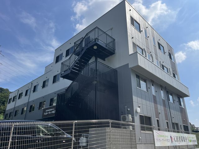 三階建ての建物外観 外観 明るい外観を持つ三階建ての建物です。周囲に緑がある開放的な環境になっています。