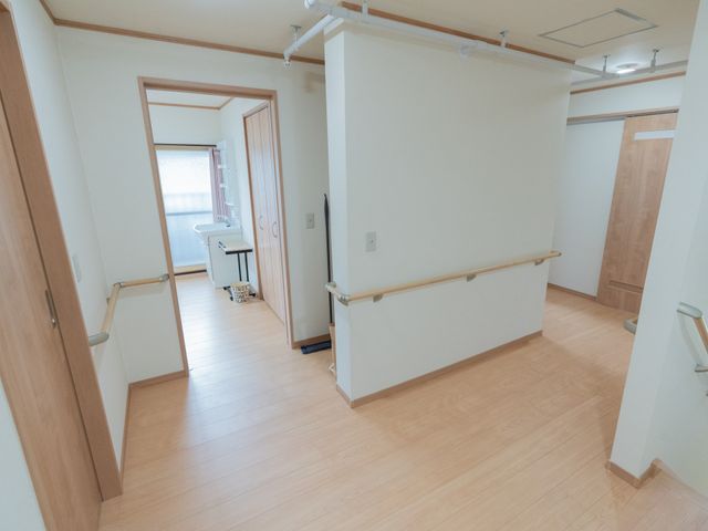 広い廊下 廊下 手すりが設置された廊下は広々としており、動きやすさが確保されています。明るい木目調の床が特徴です。