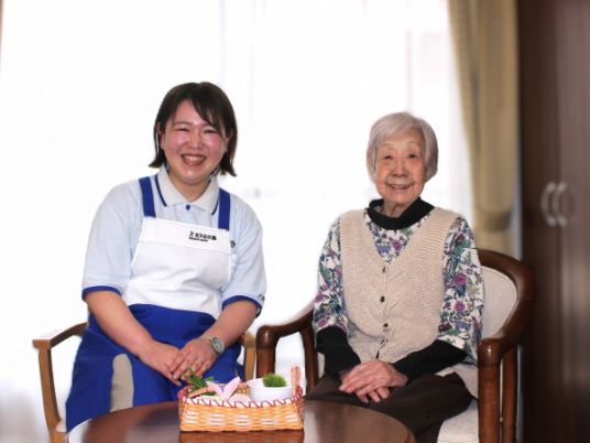 笑顔のスタッフと女性の居室