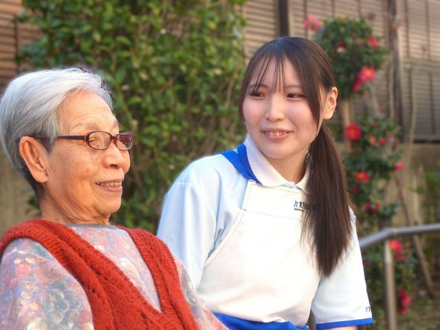 ベンチで談笑する場面 中庭 優しい雰囲気の中庭で、リラックスした時間を提供します。スタッフとの心温まる交流が魅力です。