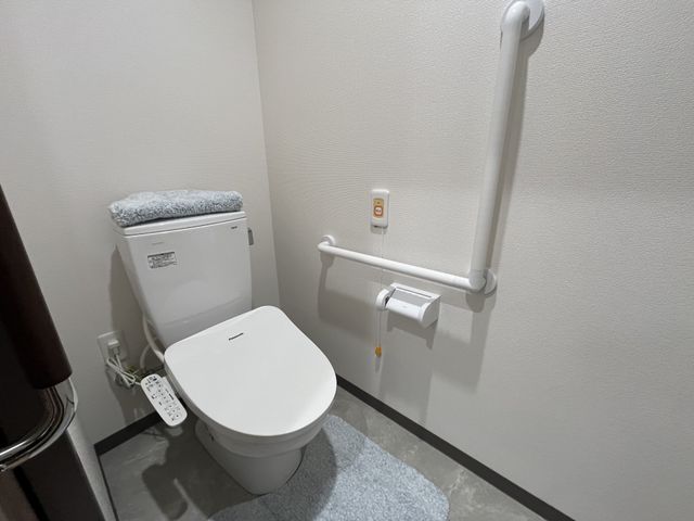 手すり付きのトイレ トイレ 手すりが付いており、安全に配慮されたトイレです。清潔感があり、快適に使用できます。
