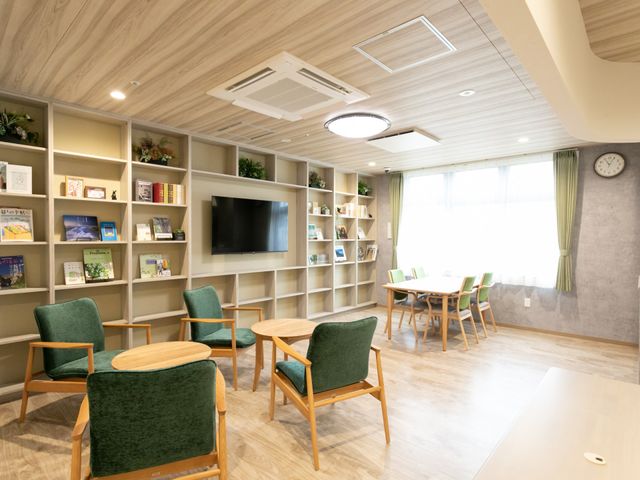 落ち着いた空間のリビング リビング 広い窓から自然光が差し込む明るい空間で、リラックスしながらくつろげる場所です。緑豊かなインテリアで心地よい環境を提供します。