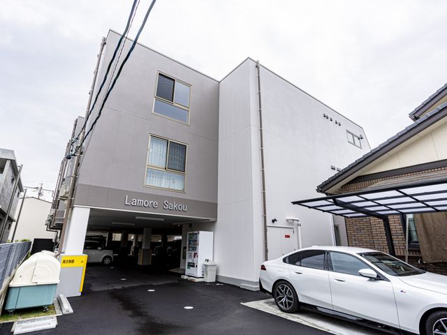 白い外壁の建物 外観 駐車スペースを完備した建物です。スタッフの通勤にも便利です。