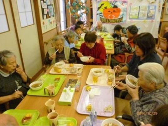 笑顔で食事を支援するスタッフ