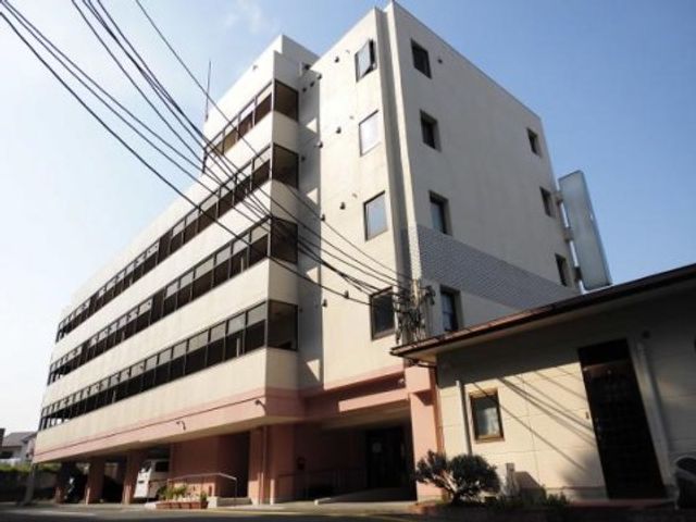 白い建物の外観 外観 日差しを反射する白い壁が特徴の建物です。落ち着いた色合いのエントランスが、訪れる方を優しく迎えます。