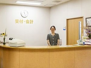 受付カウンターとスタッフの笑顔のフロント  