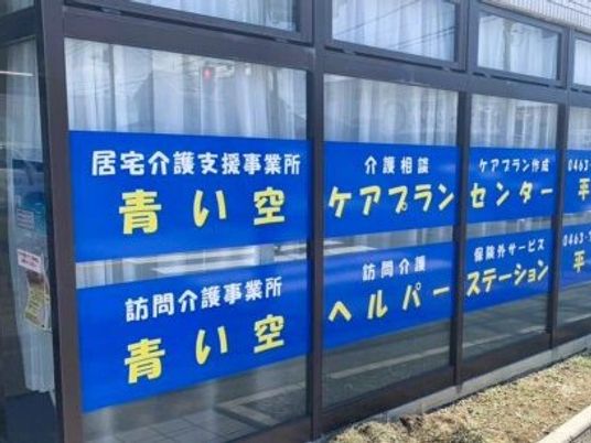 青い看板が並ぶ外観  