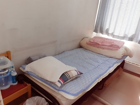 窓辺のシングルベッドのある居室