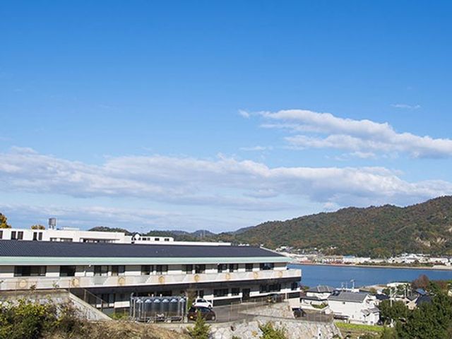 海沿いの建物外観 外観   青空の下、海と山を望む開放的な建物です。周囲の景色がよく見え、落ち着いた環境で働きやすそうです。