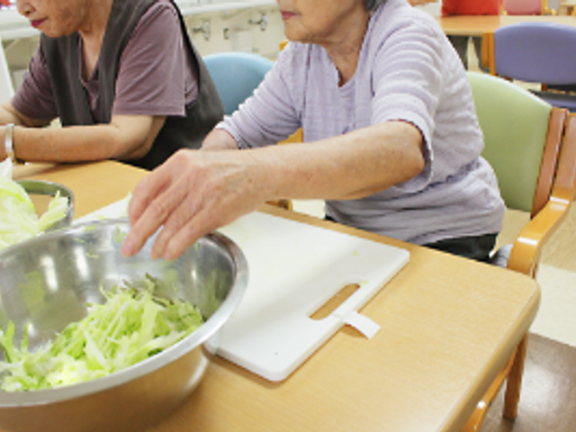 調理活動をする室内 ダイニングルーム 利用者の方々が一緒に調理を楽しむ風景です。広いテーブルで活動がしやすくなっています。