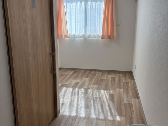 明るい居室 居室 自然光がたっぷり差し込む居室で、爽やかな空間が広がっています。柔らかい色合いのカーテンが落ち着きを感じさせます。