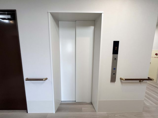 落ち着いた廊下のエレベーター エレベーター 手すりが設置された清潔感あるエレベーターです。安全に移動が可能です。