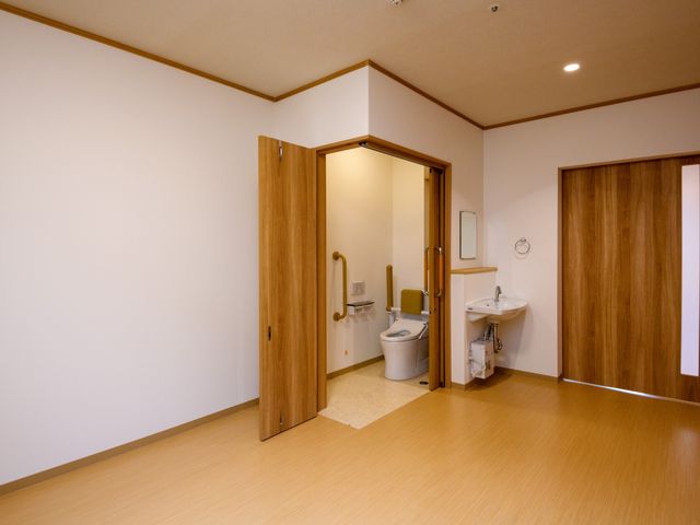 清潔感のあるトイレ トイレ 車椅子でも利用しやすい、広く機能的なトイレです。安全な手すりと明るい空間が特徴です。