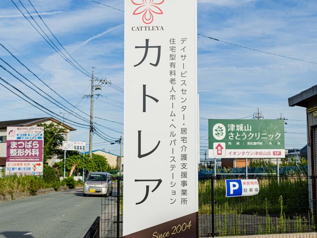屋外の施設看板 看板   青空の下に立つ大きな看板が目を引きます。住宅型有料老人ホームや支援事業所の案内があり、来訪しやすい印象です。