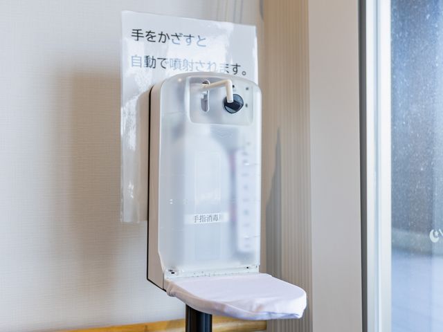 自動消毒器のある廊下 廊下   手をかざすと使える自動消毒器が設置され、衛生面に配慮した空間です。手すりもあり、移動しやすさが感じられます。