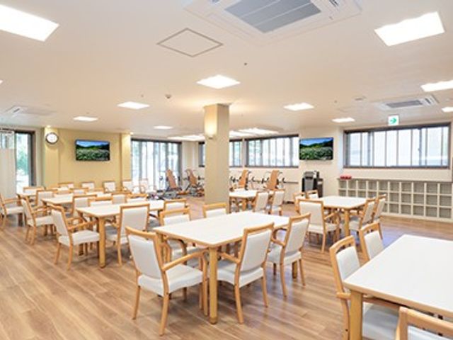 明るい食堂 ダイニングルーム   大きな窓から光が入る、ゆとりのあるダイニングルームです。テーブルが整然と並び、落ち着いて食事や会話をしやすい雰囲気です。