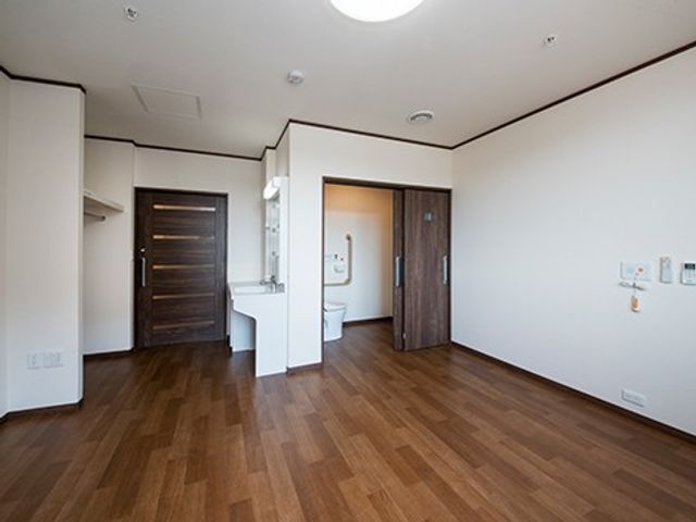 明るい居室の空間 居室   広い床面と白い壁が印象的な、すっきりした居室です。出入口や洗面まわりが見え、働く場の動線をイメージしやすいです。
