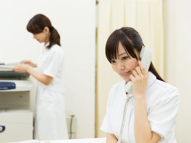 電話対応中の職員 スタッフイメージ 元気な職員が笑顔で電話対応をしており、働く環境の良さが伺えます。資格を活かした業務が可能です。