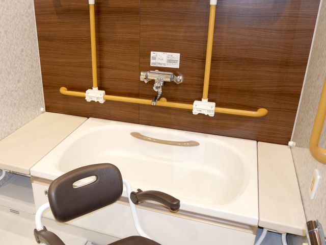 入浴設備の浴槽 浴室 手すり付きの浴槽は、安心して利用できる工夫がされています。座りやすい椅子も完備しています。