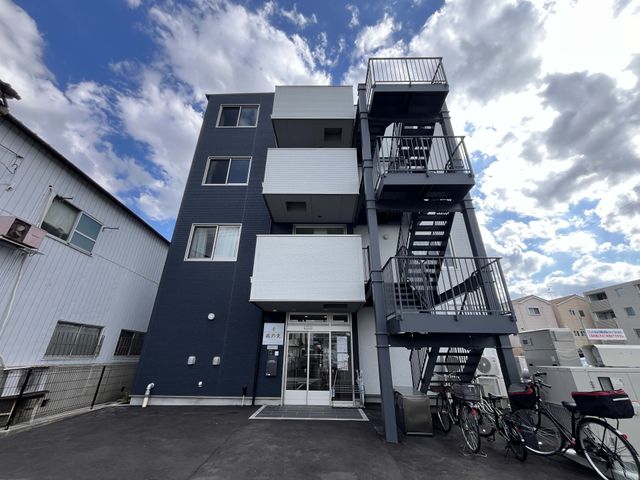 階段のある建物外観 外観 自転車置き場が設けられた現代的な建物です。複数階へアクセス可能な外階段も備えています。