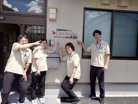 スタッフが看板前に立つ外観  