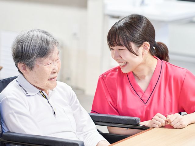 スタッフと利用者の様子 スタッフイメージ 笑顔で会話するスタッフと利用者の姿が見られ、温かいコミュニケーションが感じられます。