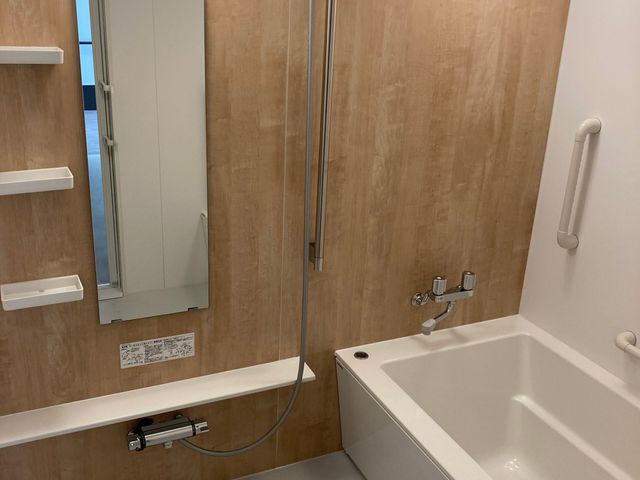 手すり付き浴室 浴室   手すりやシャワーが備わった、使いやすそうな浴室です。洗い場と浴槽が見え、入浴介助のしやすさがうかがえます。
