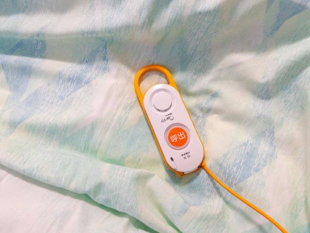 呼出ボタン付きベッド 居室   ベッド上に呼出ボタンが置かれており、必要なときにすぐ使いやすい環境です。利用者さんの近くで見守りや対応がしやすそうです。