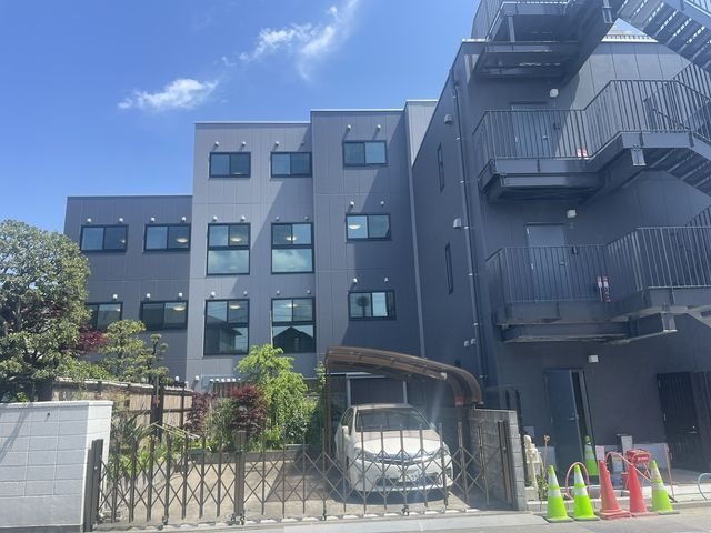 明るい屋外の建物 外観   施設のモダンな外観が印象的で、訪れる人を温かく迎え入れています。