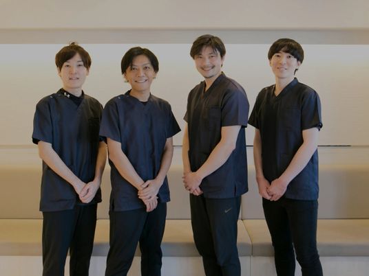 笑顔のスタッフ4人が並ぶ休憩室  