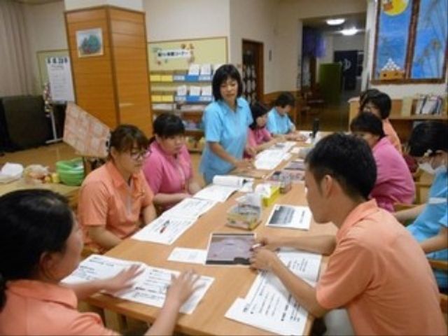 スタッフのチームワークの一場面 多目的室 仲間と力を合わせて活動を支える、やりがいのある職場です。笑顔が溢れる多目的室での一コマ。