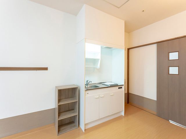 コンパクトなキッチン付き 居室 居室内には簡易キッチンが完備されており、必要な調理が可能です。シンプルで使いやすい設計です。