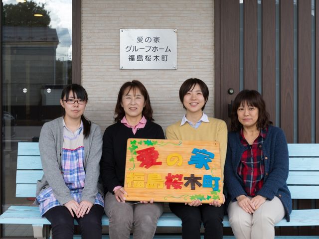 スタッフと掲示物のエントランス スタッフ 笑顔あふれるチームが迎える明るいエントランス。充実した日々を支える心強い仲間たちの姿が印象的です。