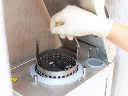 手袋で器具を操作する手元  