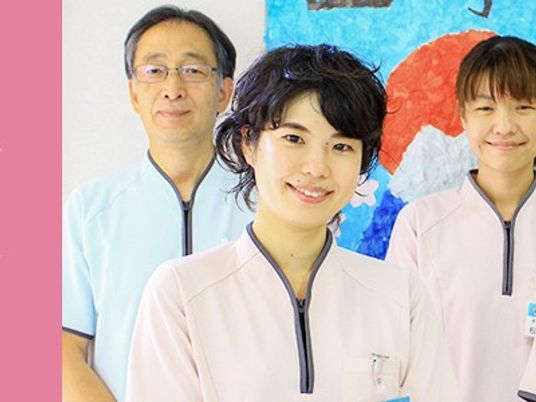 スタッフが並ぶ室内  