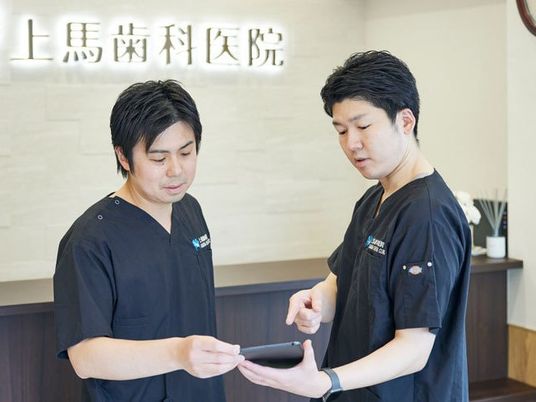 受付で確認するスタッフ  