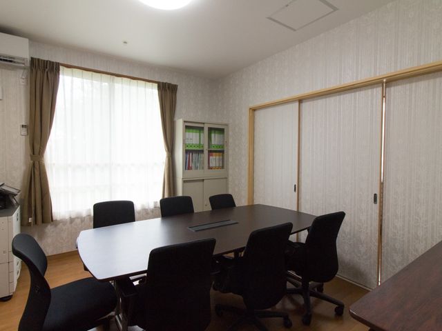 会議室の明るい居室 応接室 ゆったりとした会議テーブルと椅子が配置された落ち着いた雰囲気の多目的室です。ここでのチームミーティングやプランニングには適した環境が整っています。