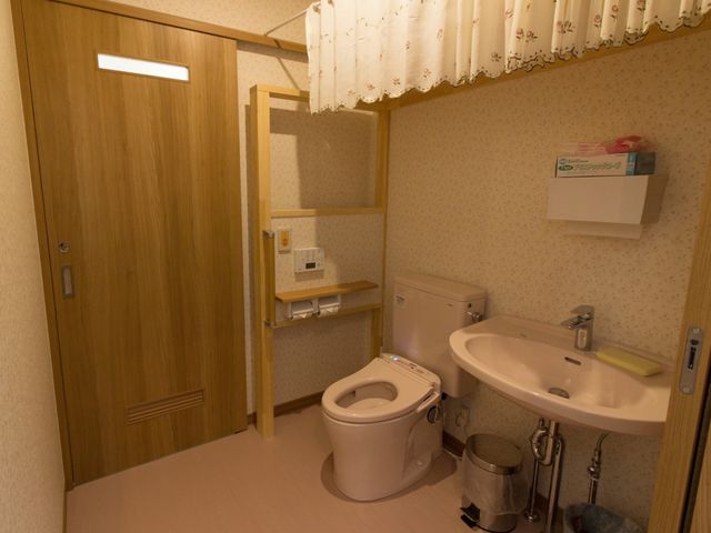 プライバシー配慮の洗面所 トイレ 手すり付きの清潔なトイレは、安全かつ快適な利用を支え、日常生活をサポートします。