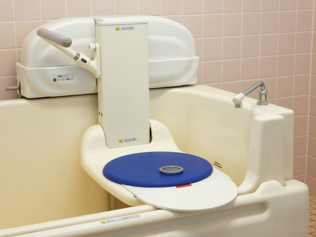 手すり付きトイレ設備 浴室 手すりと肘掛けの完備されたトイレです。立ち座りのサポートが可能で、安全性に配慮されています。