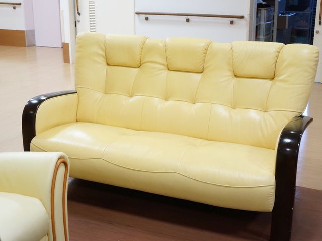 黄色いソファの居室 ソファー ゆったりとした黄色いソファが配置された休息スペースです。清潔感のある空間でリラックスした時間を過ごせます。
