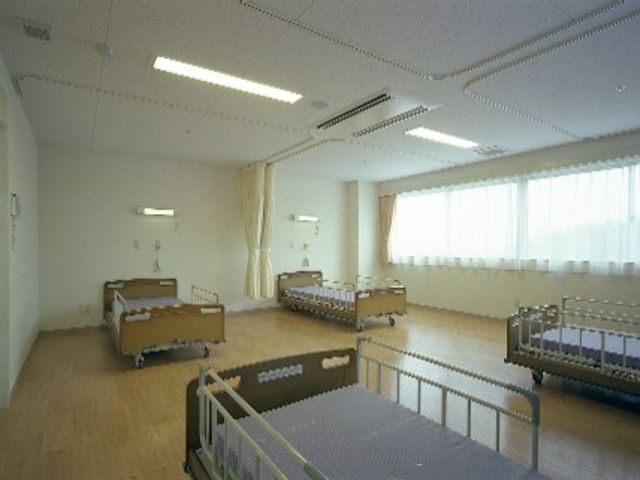 明るい居室 居室 自然光がたっぷり入る広々とした部屋で、快適な環境を提供しています。ベッド間の距離も十分確保されています。