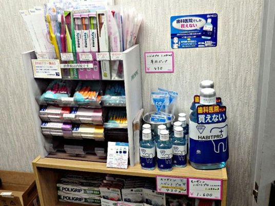 歯科用品の棚と案内板のある廊下  