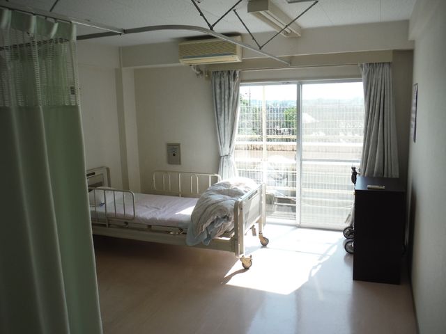 明るい個室の様子 多床室 日差しの入る快適な個室で、バルコニーからの景色も望め、ゆったりとした時間が過ごせます。ベッドの横には、必要な物が置けるスペースがあります。