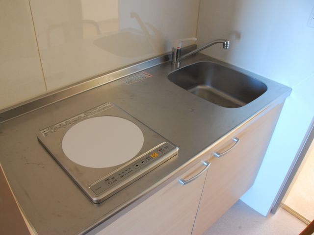 清潔なキッチンカウンター 居室キッチン シンプルで使い勝手の良いキッチンは、料理がしやすく便利です。毎日の食事作りに安心を提供します。