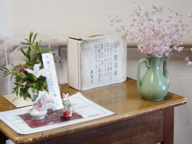 桜模様の花瓶と本 エレベーター ほっと一息つける、心温まるロビーの一角です。季節感じる装飾が、訪れる人の気持ちを和ませます。