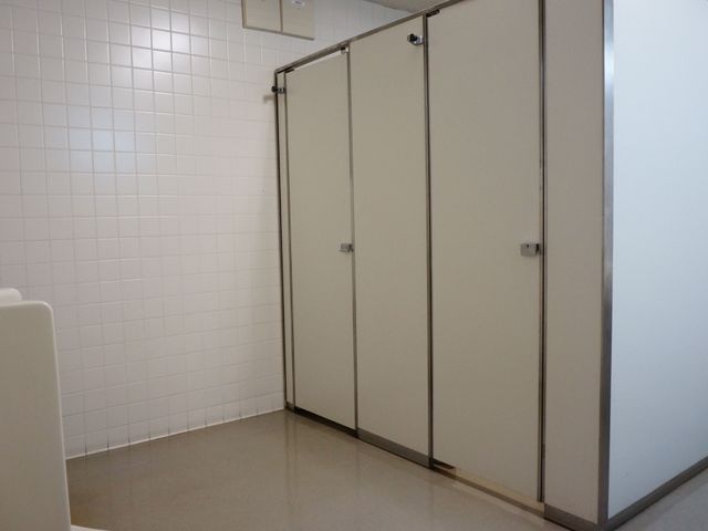 清潔なトイレの入口 トイレ ゆとりのある扉は、利用者の利便性を考慮した設計です。手すりも設置されており、支援が必要な方も安心してお使いいただけます。