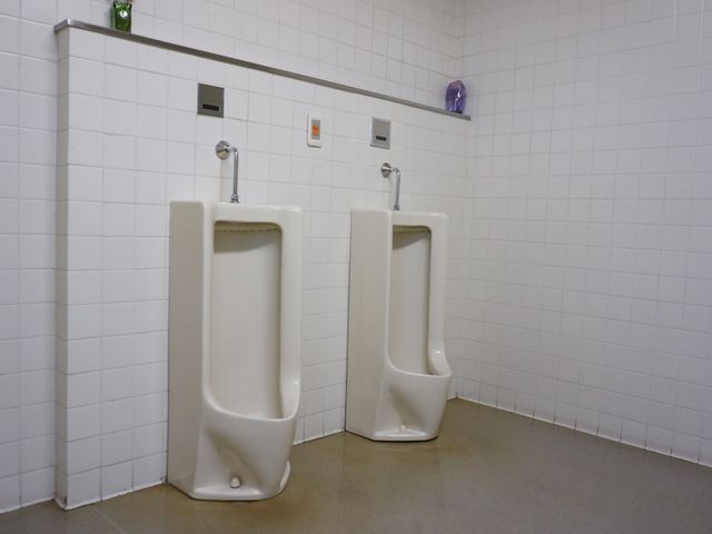 清潔なトイレの便器 トイレ 白いタイル張りの清潔感のあふれるトイレスペースです。手入れが行き届いており、快適にご利用いただけます。